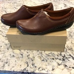 Size 9w Dark tan Clark’s Ashland Joy leather slip-ons with top-stitch styling.